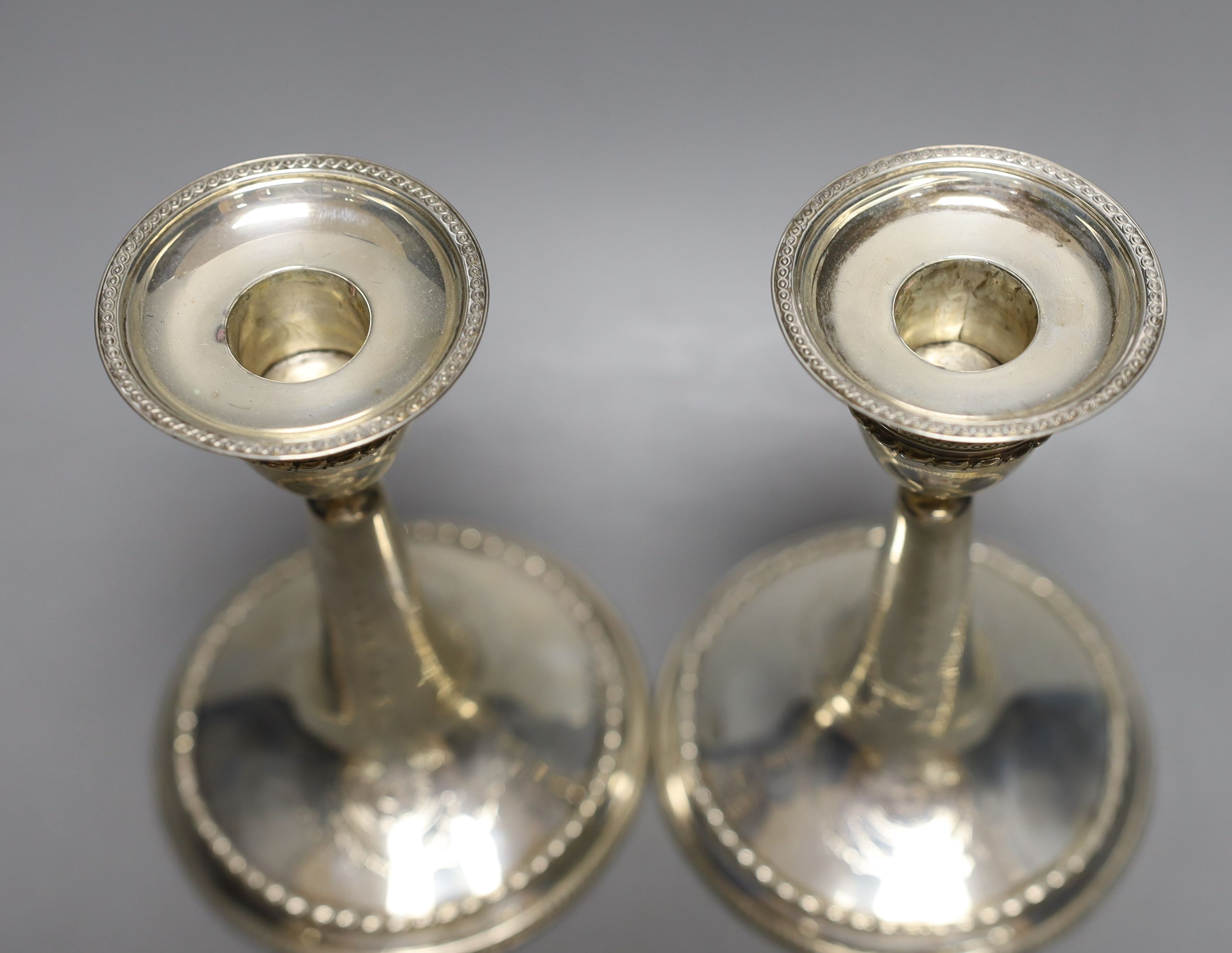 A pair of Edwardian silver mounted dwarf candlesticks, William Comyns, London, 1906, height 14.7cm, weighted.